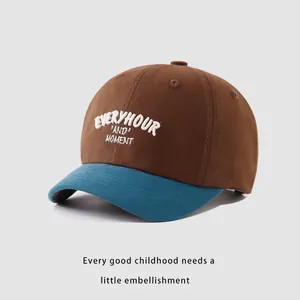 Detail of embroidered 'EVERYHOUR' text on contrast color kids cotton baseball cap