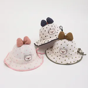 Detail of baby sun hats with polka dots, bear embroidery and decorative 3D bow