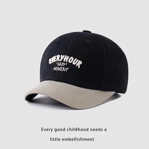 Detailed embroidery texture on a black and beige cotton baseball cap for kids