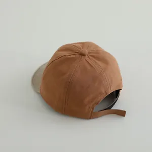 Detail of adjustable velcro strap and premium brown texture on infant baseball cap