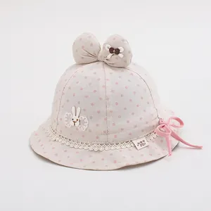 Detailed view of pink polka dot baby sun hat with large bow and cute rabbit patch