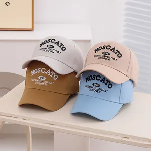 Gros plan de quatre casquettes de baseball en coton colorées avec broderie 1996 sur table