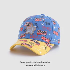 Détail de la casquette enfant avec imprimés graffiti multicolores et écusson étoile brodé