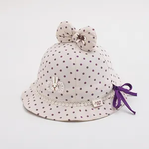 Detail of baby sun hat with purple polka dots, lace trim, and cute rabbit patch