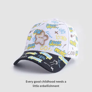 Détail d'une casquette enfant avec motifs graffiti colorés et un ornement en forme d'étoile