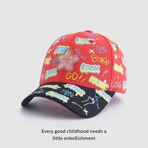 Détail de casquette enfant avec imprimés graffiti LOOK et écusson en forme d'étoile