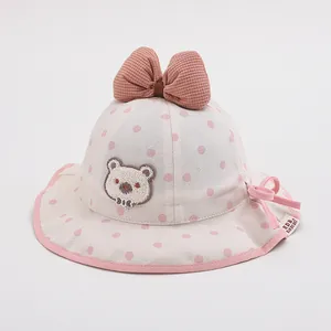 Detailed close-up of baby sun hat featuring pink polka dots and bear embroidery