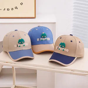 Kids dinosaur baseball caps in three colors displayed on a minimalist white shelf