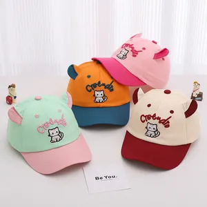 Détail de casquettes enfant colorées avec oreilles de chat 3D et broderie dessin animé