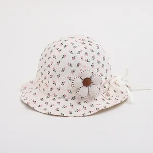Close-up of floral baby sun hat fabric featuring 3D fabric flower and brand label detail