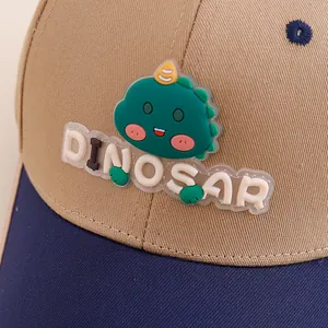 Close-up of green 3D dinosaur patch and DINOSAUR text on kids cotton baseball cap