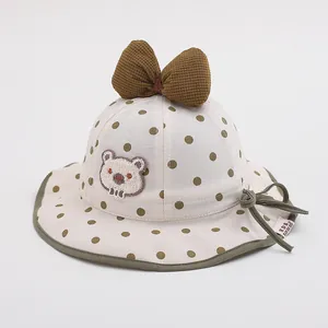 Detail of baby sun hat with polka dots, brown knit bow and cute bear embroidery