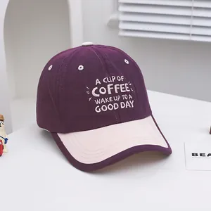 Detail of white COFFEE quote embroidery on a deep purple and pink kid's baseball cap