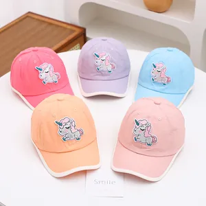 Détail de casquettes enfant colorées avec écussons licorne pailletés et tissu en maille