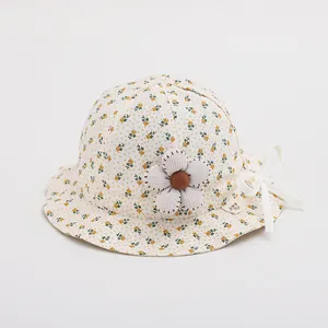 Detailed macro view of baby sun hat with yellow floral pattern and fabric flower decor