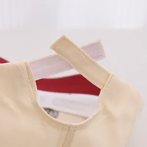 Détail macro d'une casquette bébé en toile beige avec fermeture velcro réglable à l'arrière