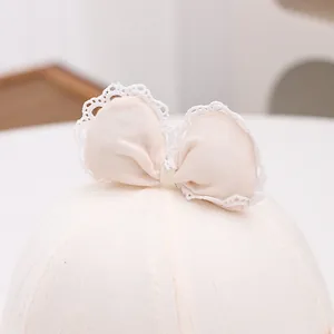 Detail of pink baby sun hat showing lace-edged bow and breathable textured embroidery