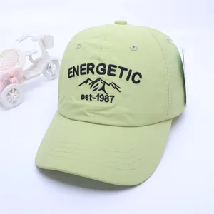 Detail of light green baseball cap with black energetic embroidery and fabric texture