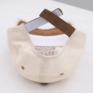 Macro view of adjustable Velcro strap and embroidered eyelets on the two-tone baseball cap