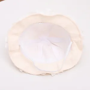 Close-up of baby sun hat interior showing soft lace trim and elastic chin strap detail