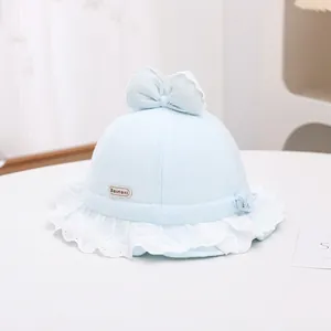 Close-up of light blue baby sun hat with delicate white lace trim and cute bow detail