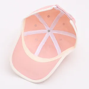 Détail de l'intérieur d'une casquette rose montrant les coutures à six pans et le bandeau