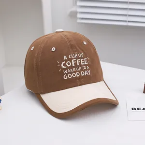 Detail of embroidered coffee quote on a brown and beige two-tone kids baseball cap