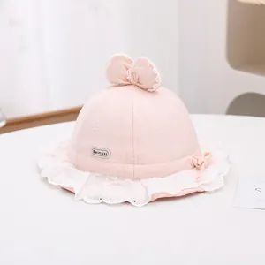Close-up of pink baby sun hat with delicate lace trim and bow knot decoration