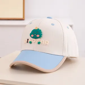 Close-up of beige and blue baseball cap featuring a 3D green dinosaur and DINOSAR text