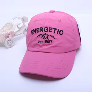 Detail of rose pink baseball cap featuring black energetic embroidery and sturdy stitching