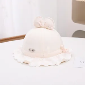 Detailed close-up of pink baby sun hat featuring lace floral edges and a cute bow