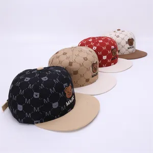 Detail showing colorful snapback caps with bear embroidery and M pattern print
