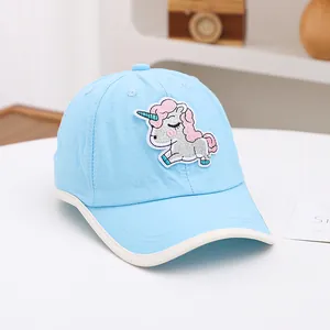 Détail de la casquette enfant bleu clair avec broderie licorne et passepoil blanc pur