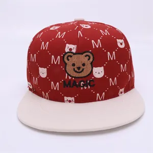 Detail of bear embroidery and white letter M pattern on a red kids hip-hop baseball cap