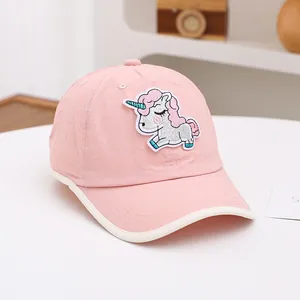 Détail de la casquette rose pour enfant avec écusson licorne pailleté et liseré blanc