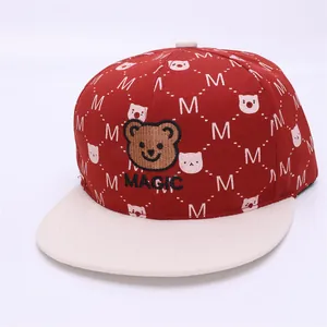 Detail of red and white kids baseball cap featuring bear embroidery and M pattern