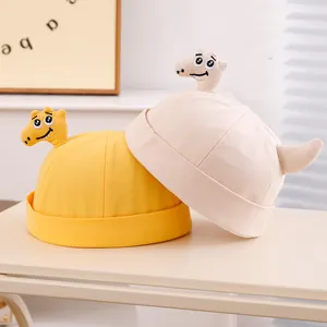 Dettaglio del cappello Miki per neonati con ricamo a dinosauro in cotone giallo e beige