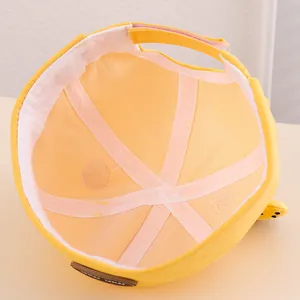 Dettaglio interno del cappello giallo per neonati con fodera morbida e cinturino regolabile