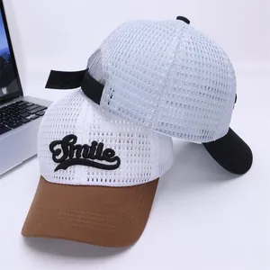 Détail de casquettes de baseball en mesh respirant avec broderie Smile et visière