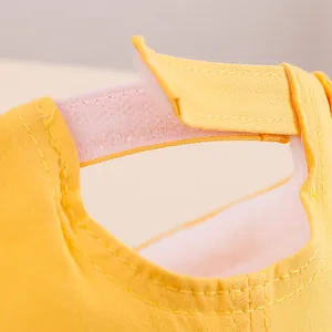 Dettaglio del cinturino in velcro regolabile su un cappello giallo per bambini