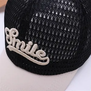 Détail de la couronne en maille et broderie Smile sur une casquette trucker enfant