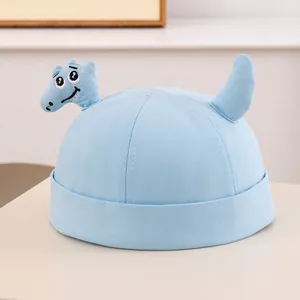 Dettaglio del cappello in cotone azzurro per neonato con ricamo dinosauro 3D carino