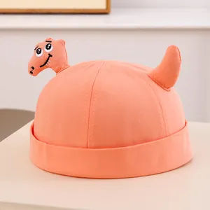 Dettaglio del cappello Miki arancione per neonati con dinosauro 3D e coda applicata