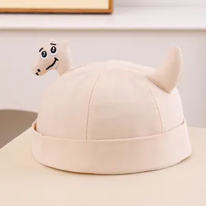 Dettaglio del berretto beige per bambini con simpatico ricamo dinosauro 3D in cotone