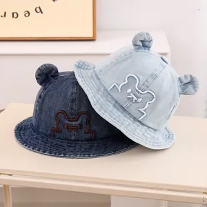 Detailed macro view of denim baby sun hats with cute bear ears and embroidery textures