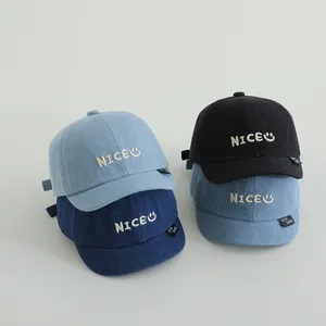 Detail of embroidered denim baseball caps for kids with NICE logo in four colors