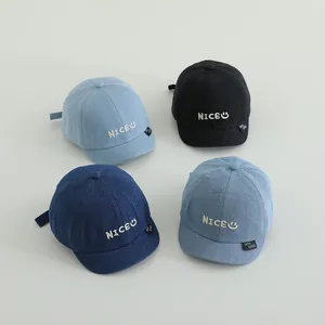 Flat lay of baby denim baseball caps in four colors featuring NICE embroidery detail