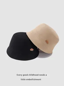 Detail of kids cotton bucket hats in black and khaki with leather cloud patch