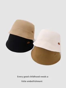 Detail of four colorful kids bucket hats stacked with cloud leather patch and cotton fabric