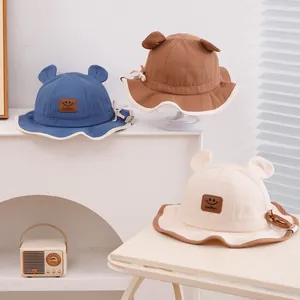 Détail de chapeaux de pêcheur pour enfants avec oreilles et écusson Lucky souriant